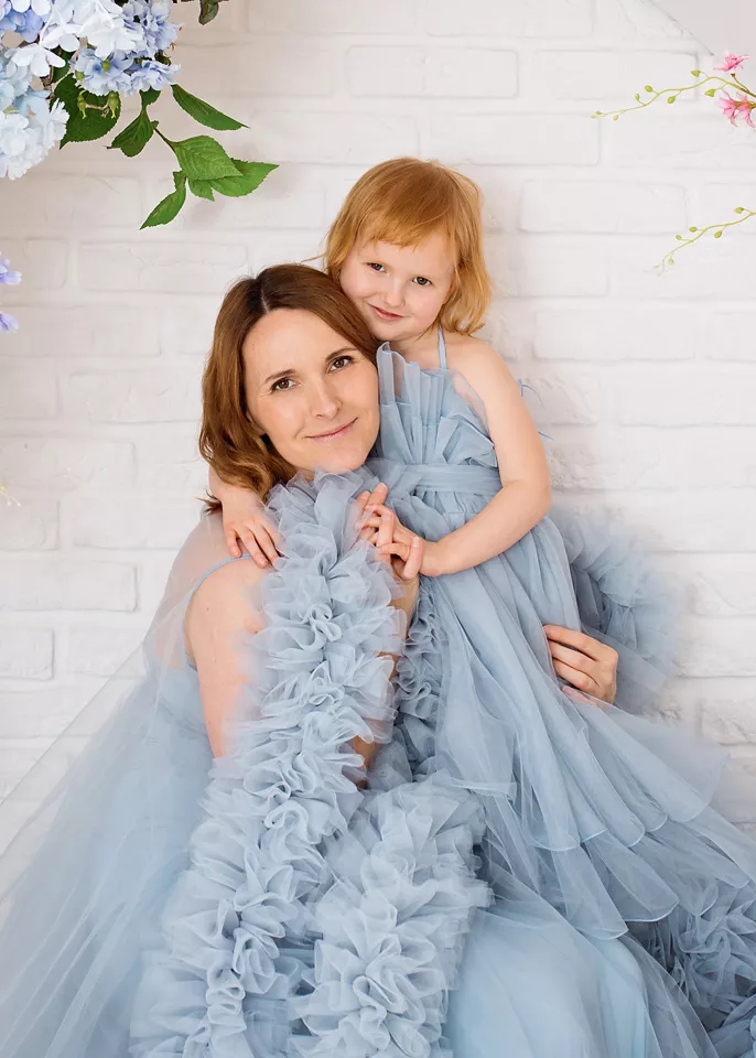 Sesja rodzinna w kwiatach — mama i córka w tiulowych sukienkach w studio w Warszawie